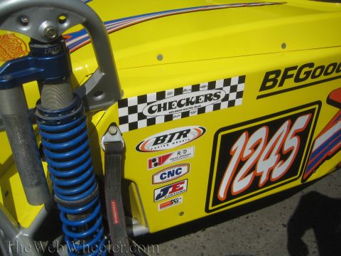 1990 Ford Bronco - Close-up of a yellow race car body panel showing number 1245, a blue coilover shock and Checkers and BTR sponsor decals.