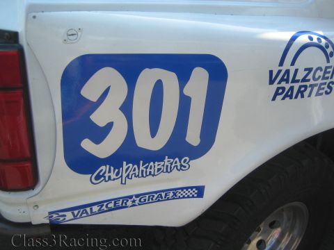 1990 Ford Bronco - close view of a white race truck's rear quarter shows a blue number 301, Chupakabras, and Valzcer Partes/Grafx decals.