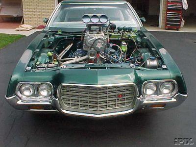 1972 Ford Ranchero - A green 1972 Ford Ranchero is shown from the front with its hood open, revealing a powerful engine and supercharger.
