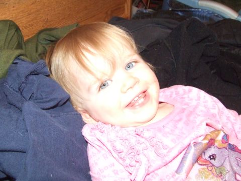 1990 Ford Bronco - A smiling baby girl with blonde hair and blue eyes is pictured in this close-up photo.