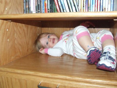 1990 Ford Bronco - A baby is lying on a shelf, surrounded by books.