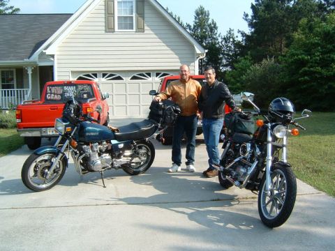 1985 Ford LTD Crown Victoria - Two men and their motorcycles are parked in a driveway with a house and a red pickup truck in the background.