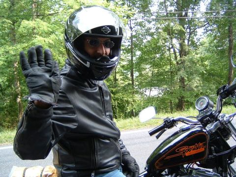 1985 Ford LTD Crown Victoria - Motorcyclist in full gear poses for a photo while seated on a motorcycle.