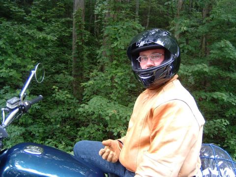 1985 Ford LTD Crown Victoria - A rider pauses their journey amidst the dense green foliage of a forest.