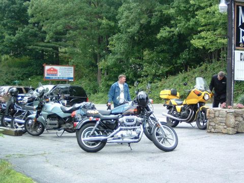 1985 Ford LTD Crown Victoria - Motorcycles parked outside a Ramada Inn, with two men nearby.