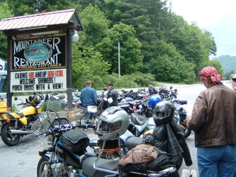 1985 Ford LTD Crown Victoria - A group of motorcycles are parked outside a restaurant with a sign indicating it also offers fireside cottages.