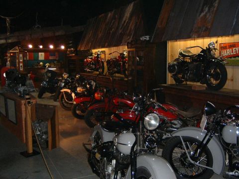1985 Ford LTD Crown Victoria - Indoor display of multiple vintage motorcycles, including a 1941 Harley-Davidson.