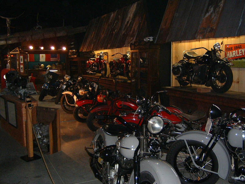 Several vintage motorcycles displayed indoors, with a sign reading 'The 1941 Harley'