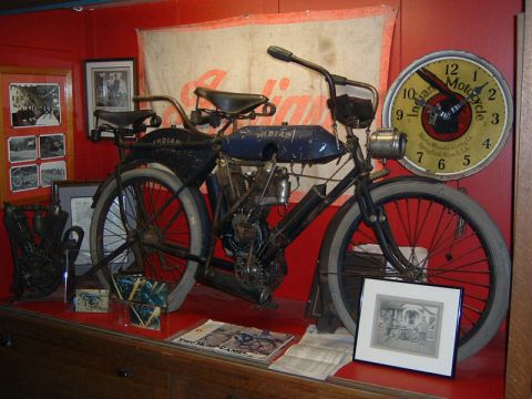 1985 Ford LTD Crown Victoria - An antique Indian motorcycle is displayed indoors with historical memorabilia.