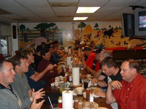 1985 Ford LTD Crown Victoria - Diner scene with people gathered around a long table, enjoying a meal.
