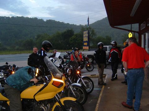 1985 Ford LTD Crown Victoria - Motorcyclists gather outside a BBQ restaurant on a cloudy day.