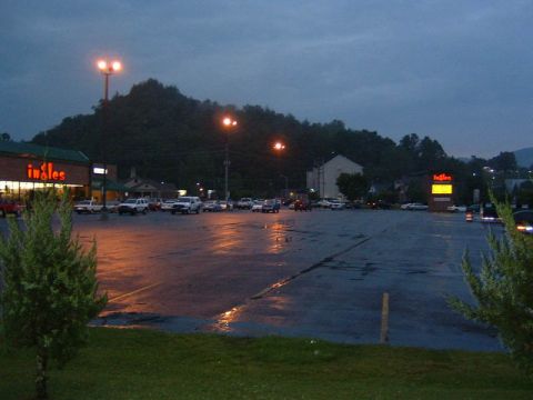 1985 Ford LTD Crown Victoria - Dusk scene of a wet parking lot outside an Ingles grocery store with multiple vehicles.