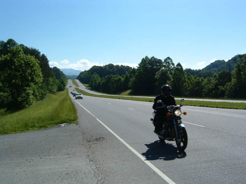 Motorcyclist riding on a highway with other cars in the distance