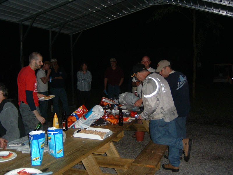 People gathered around a picnic table at night