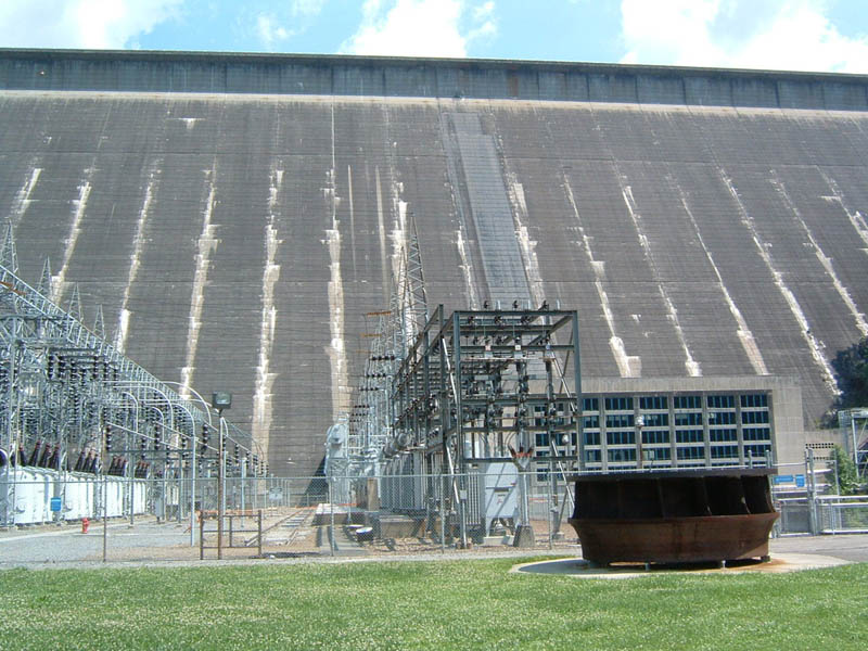 Hydroelectric dam with power station equipment and grassy foreground