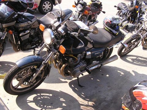 1985 Ford LTD Crown Victoria - Multiple motorcycles are parked together outdoors on a sunny day.