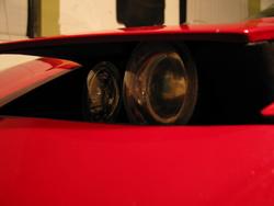 1997 Ford Probe - The front headlight assembly of a red vehicle is shown in this close-up shot.