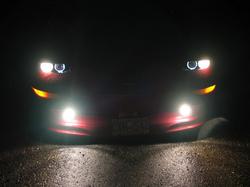 1997 Ford Probe - A red car is seen from the front at night with its headlights and fog lights illuminated.