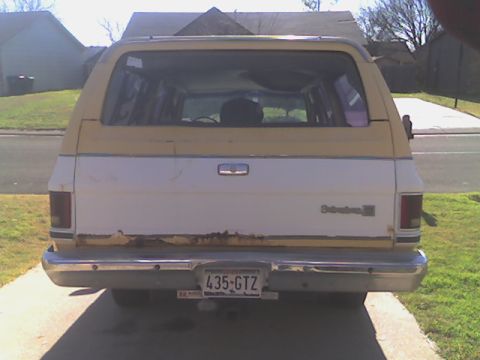 1984 Chevrolet Suburban - Rear view showing the rusted tailgate and Class V receiver.