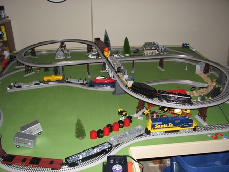 1991 Ford Bronco - A detailed model train set is displayed on a green surface, various locomotives and carriages on intricate track layouts.