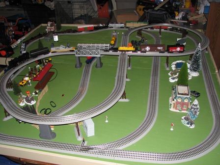 1991 Ford Bronco - A detailed model train set is laid out with various tracks, bridges, and miniature buildings.