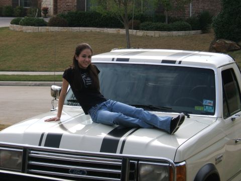 1991 Ford Bronco - Close front three-quarter view of a white late-1980s Ford Bronco with twin black racing stripes running over the hood and roof, chrome gril…