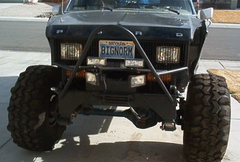 1986 Ford Bronco - This heavily modified Ford truck features oversized tires and a robust front bumper with multiple lights.