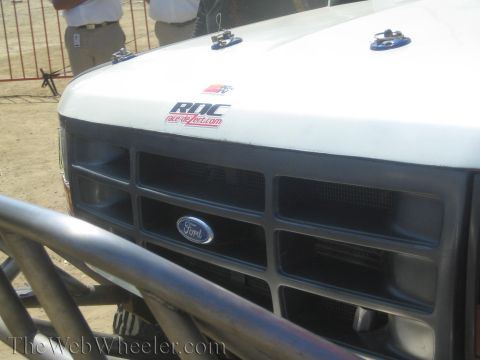1990 Ford Bronco - close-up of a white off-road truck's hood and Ford grille shows hood pins and an RDC racedesertfun.com sticker.