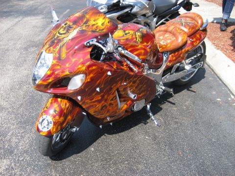 1986 Ford Bronco - A motorcycle with a custom flame and skull paint job is parked next to another motorcycle.