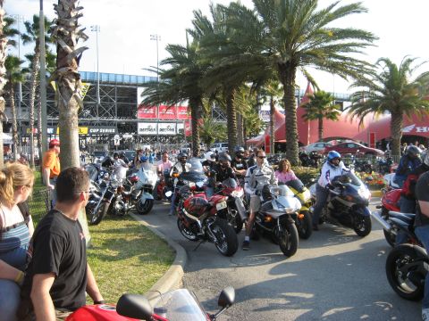 1986 Ford Bronco - A crowd of motorcycles gathers near a stadium, with many riders present.