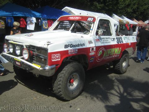 1990 Ford Bronco - white-and-red number 303 race truck lettered 'California Tomatoes' with BFGoodrich and Bilstein decals and a row of front lights.