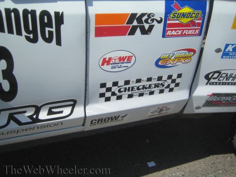 1990 Ford Bronco - Detail of a white race truck door covered in sponsor decals including K&N, Sunoco Race Fuels, Howe, and Checkers.