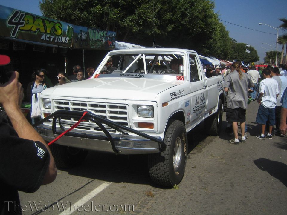 White Ford off-road race truck number 861 with tube bumper at street event