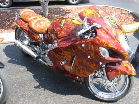 1986 Ford Bronco - A custom motorcycle with a flame paint job and unique seat design is parked outdoors.