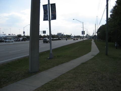 1986 Ford Bronco - A wide highway with multiple lanes of traffic and a sidewalk running alongside.