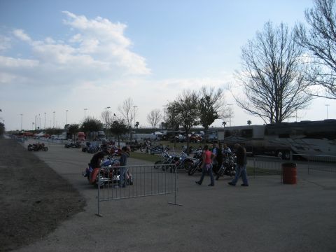 1986 Ford Bronco - A large gathering of motorcycles and people in an open area under a cloudy sky.