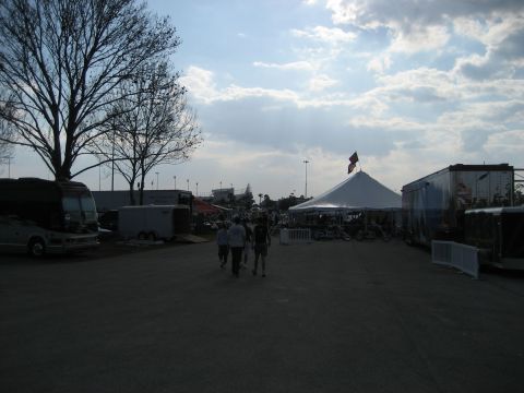 1986 Ford Bronco - A wide shot of an outdoor event with tents, trailers, and people milling about under a partly cloudy sky.