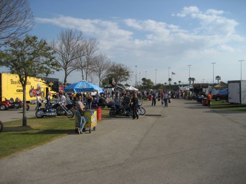 1986 Ford Bronco - Motorcycle rally scene with vendors and attendees under a bright, cloudy sky.