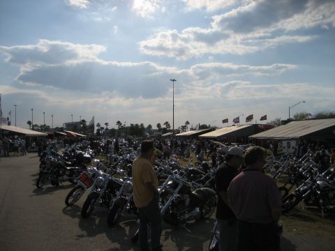 1986 Ford Bronco - A large gathering of motorcycles under a cloudy sky, with vendors and attendees present.
