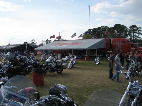 1986 Ford Bronco - Outdoor event with numerous motorcycles gathered near a large tent and a decorated red truck.
