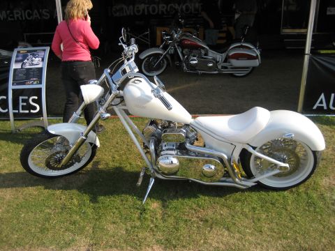 1986 Ford Bronco - A custom white motorcycle is displayed on grass, with another motorcycle visible in the background under a tent.