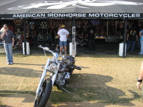 1986 Ford Bronco - A motorcycle is displayed outside an American Ironhorse Motorcycles tent with people browsing inside.