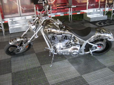 1986 Ford Bronco - A custom motorcycle with a detailed skull graphic paint job is displayed on a checkered floor.