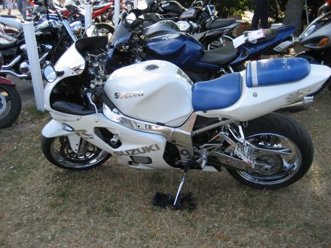 1986 Ford Bronco - A white Suzuki sportbike is parked on grass, surrounded by other motorcycles.
