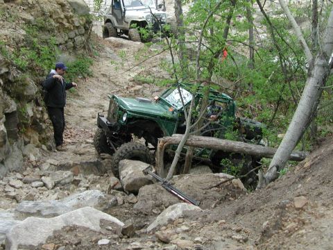 1992 Ford Bronco - Two off-road vehicles tackle a challenging rocky terrain, with one vehicle prominently featured on the trail.