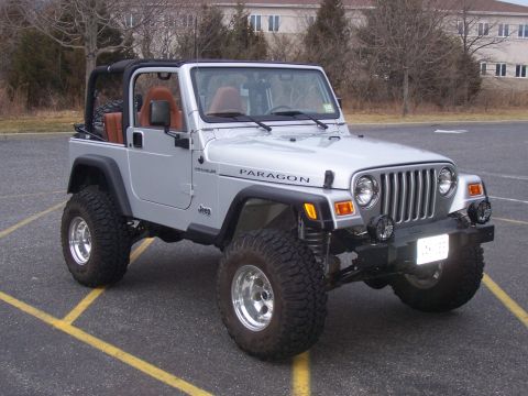 2002 Jeep Wrangler - This 2002 Jeep Wrangler features a lifted suspension and off-road tires, with a visible "PARAGON" decal on the hood.