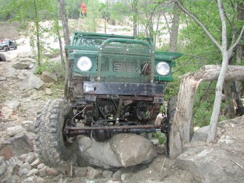 1992 Ford Bronco - Off-road vehicle navigates difficult terrain, getting stuck on large rocks.