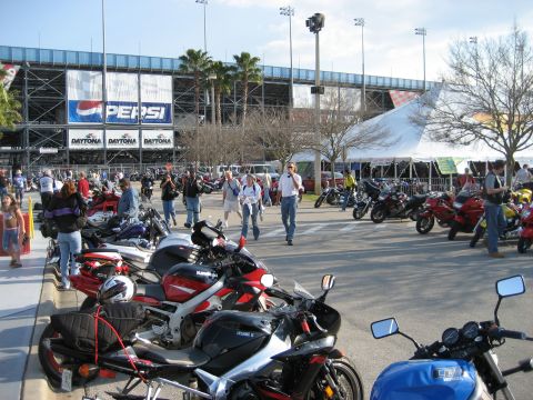 1986 Ford Bronco - A large gathering of motorcycles are parked outside a stadium, with prominent Pepsi and Daytona branding visible on the structure.