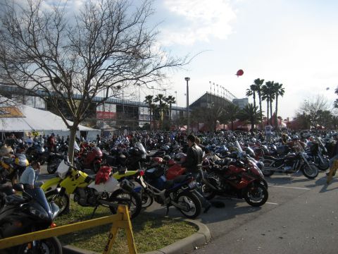1986 Ford Bronco - A large gathering of motorcycles fills a parking lot under a partly cloudy sky.