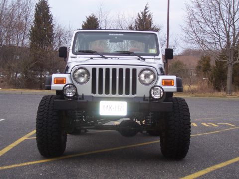 2002 Jeep Wrangler - This Jeep Wrangler features a lifted suspension and aggressive off-road tires, presented in a front-facing view.